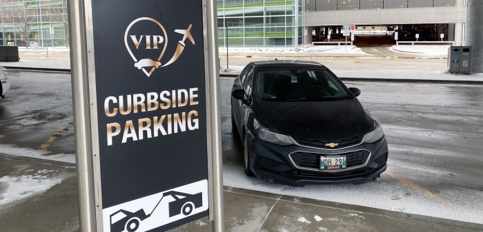 VIP Curbside area showing signage next to a parked vehicle