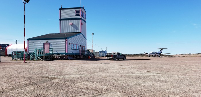 An airport in the territory of Nunavut with an aircraft in front