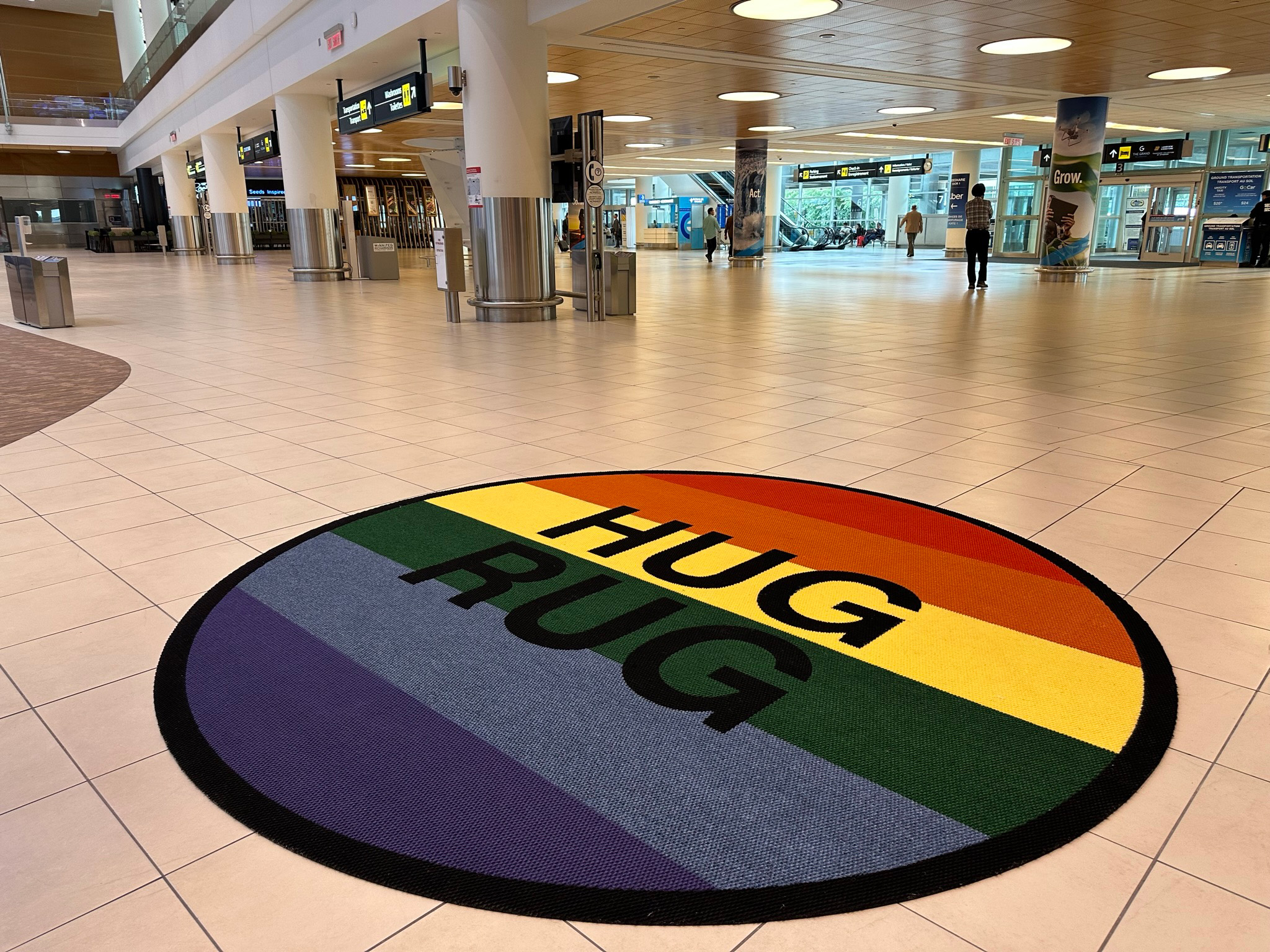 Un Hug Rug sur le thème de la fierté est exposé dans le hall des arrivées de l'aéroport international Richardson de Winnipeg.