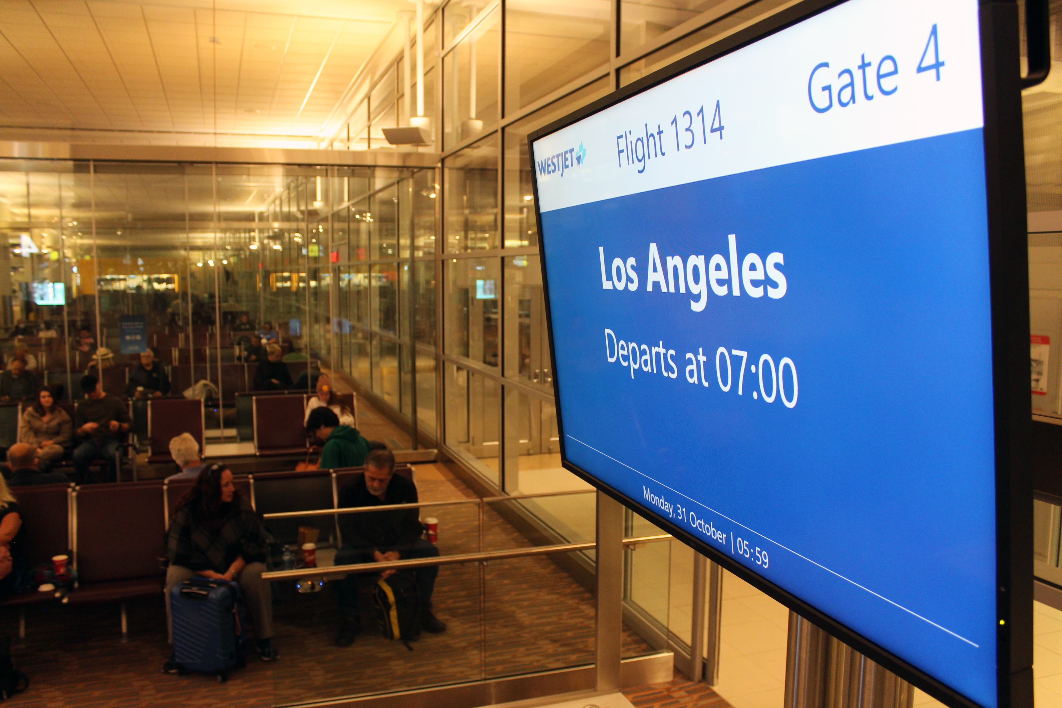 Los Angeles est indiqué sur l'écran d'information de vol situé au-dessus du comptoir d'enregistrement de la porte d’embarquement 4 de l'aéroport international de Winnipeg Richardson.