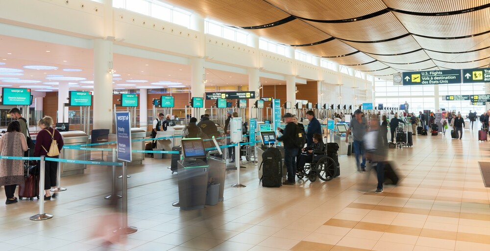 Les voyageurs passent devant les comptoirs d'enregistrement au niveau des départs de l'aéroport international Richardson de Winnipeg.